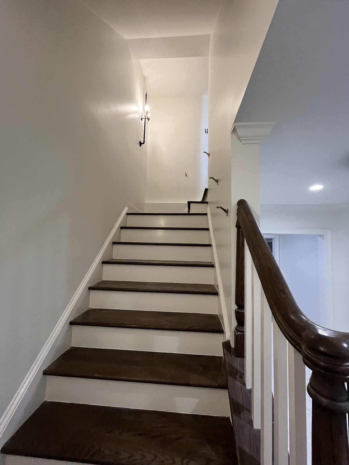 Bright white stairwell with dark stained wood treads